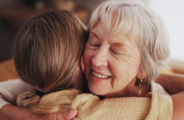 A mature patient in hospice care embraces their loved one.