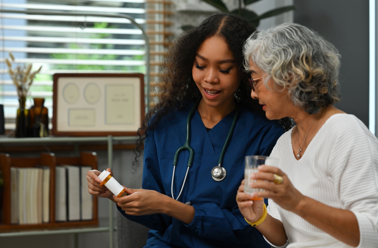 A hospice care nurse helping their patient with medication management.