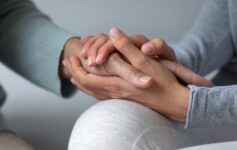 Two people are holding each other's hands to show support and care for each other.